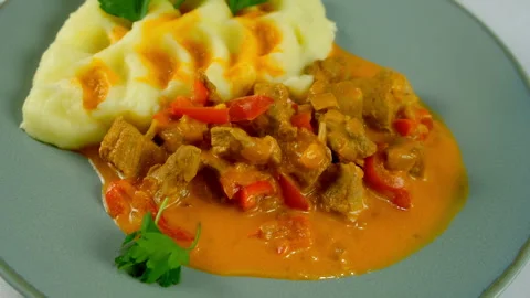 Served goulash and mashed potatoes with greenery on plate on kitchen at home. Stock Footage 312403429
