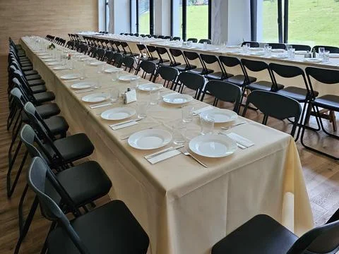 Served long table in a large dining room. Cutlery on the table. Wedding tab.. Stock Photos