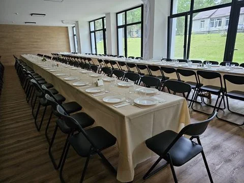 Served long table in a large dining room. Cutlery on the table. Wedding tab.. Stock-Fotos