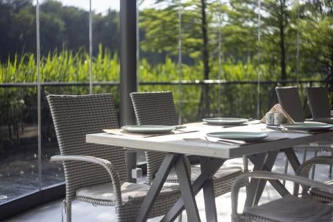 Served restaurant table on terrace with wicker chairs and scenic nature view Foto stock