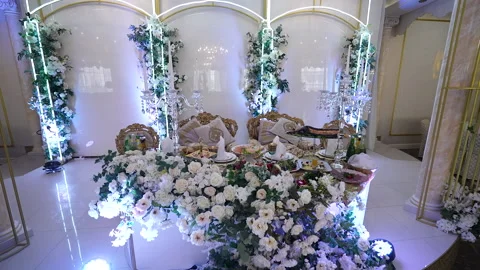 Served table with comfortable chairs and white flowers decor Stock Footage 217725123