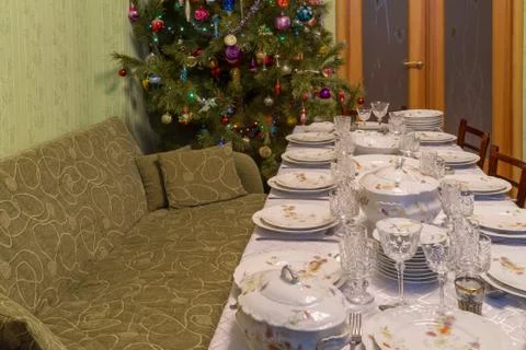 Served table with festive tableware near beautiful decorated Christmas tree i Stock Photos