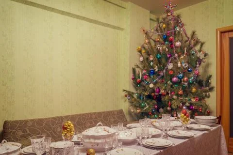 Served table with festive tableware near beautiful decorated Christmas tree i Stock Photos