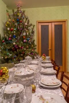 Served table with festive tableware near beautiful decorated Christmas tree i Stock Photos