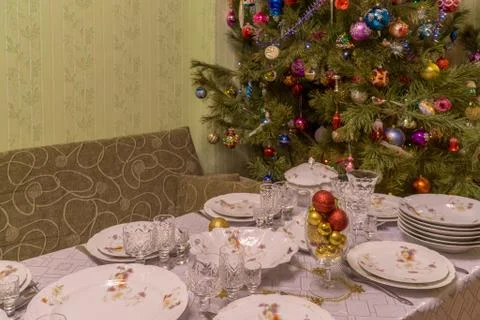 Served table with festive tableware near beautiful decorated Christmas tree i Stock Photos