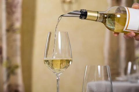 Served table restaurant wine being poured into glass, white tablecloth, plate Stock Photos