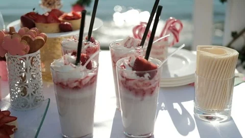 Served table by sea with sweet things for banquet on fresh air outdoors Stock Footage 76808233
