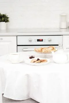 Served table with Thin pancakes with berries jam on glass stand with jam, bottle Stock Photos