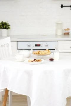 Served table with Thin pancakes with berries jam on glass stand with jam, bottle Stock-Fotos