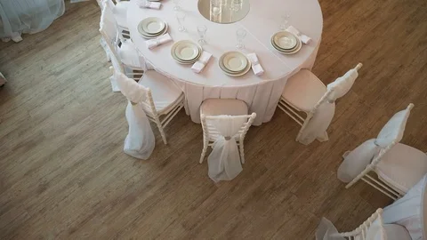 A served table with a white cloth on which there are plates and napkins Stock Footage 97717623