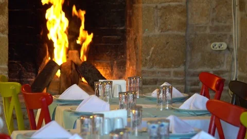 Served table with wine glasses next to the fireplace in the restaurant Stock Footage 85460742