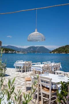 Served tables in a Greek tavern in Vathy Harbor, Meganisi island, Ionian Se.. Stock Photos
