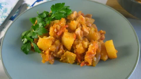 Served vegetables potatoes and chicken meat stew with parsley on plate. Stock Footage 312470035