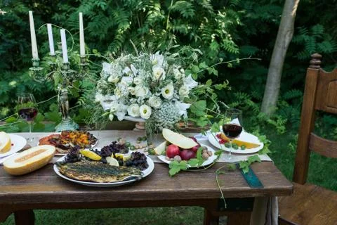 Served wedding table for dinner with delicious fruits and a glass of red wine Stock Photos