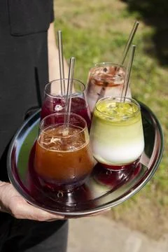 Server carrying tray with assorted cold drinks Stock Photos
