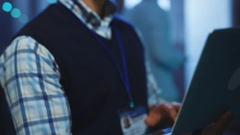 Server data IT specialist running diagnostics test on laptop with computer rack Stock Footage 118590339