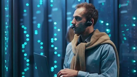 Server engineer working on laptop computer in high tech room tapping one button Stock Footage 119977020