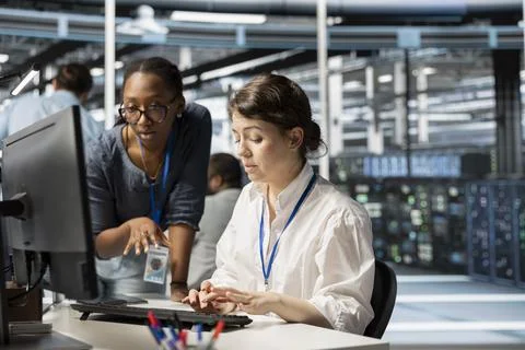 Server farm colleagues using computer to analyze facility data patterns Foto stock
