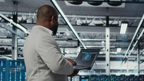 Server farm IT specialist using laptop to improve deep learning AI systems Foto stock