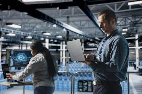 Server farm team of technicians debugging machine learning scripts on laptop Stock Photos