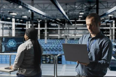 Server farm team of technicians using devices to run AI software tests 스톡 사진