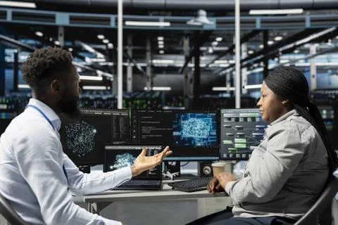 Server farm teamworking colleagues using AI algorithms Stock Photos