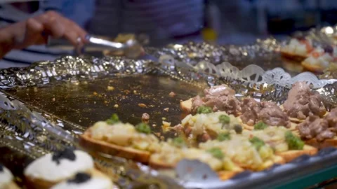 Server hand serving small tapas from ornate catering tray at gourmet buffet Stock Footage 337971440
