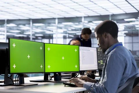 Server hub admin using green screen computer to find firewall misconfigurations Stock Photos