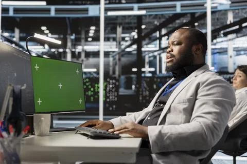 Server hub engineer looking at data visualization on green screen PC Foto stock