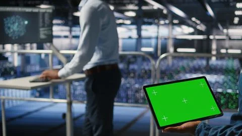 Server hub engineers finetuning configurations using chroma key device, close up Stock Photos