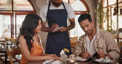 Server, menu and couple in restaurant for date, connection or bonding on weekend Stock-Fotos