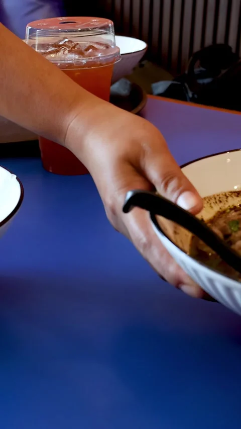 Server Placing Bowl of Thai Boat Noodles on Blue Restaurant Table Stock Footage 336531940