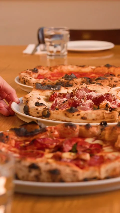 Server Placing Fresh Neapolitan Pizza on a Restaurant Table Stock Footage 338424695