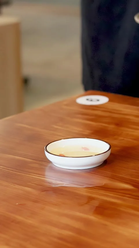 Server Placing Vietnamese Banh Beo Rice Cakes on Wooden Restaurant Table Stock Footage 337917854