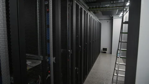 Server Rack Aisle with Maintenance Ladder in Dimly Lit Data Center Stock Footage 330546067