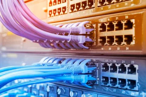 Server rack with blue and red internet patch cord cables connected to black p Stock Photos