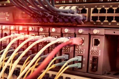 Server rack with blue and red internet patch cord cables connected to black p Stock Photos