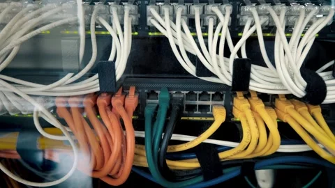Server racks with white, yellow and orange internet patch cords connected Stock Footage 304890906