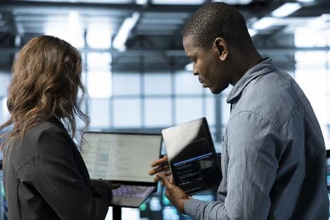 Server room admins using devices to implement sustainable energy solutions Foto stock