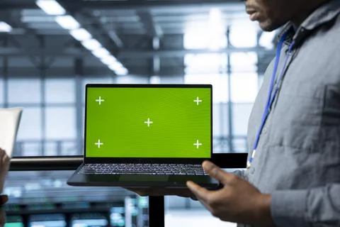 Server room admins using devices to implement sustainable energy solutions 写真素材