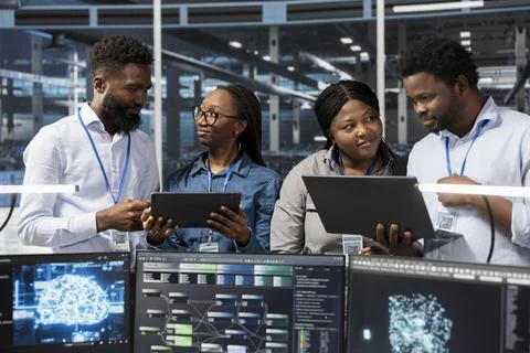 Server room colleagues use artificial intelligence to perform computing tasks Stock Photos