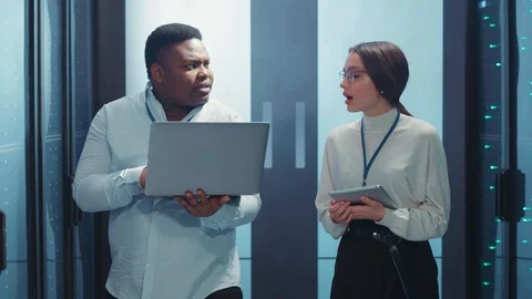 In server room couple of mixed-race engineers man and woman talking about work Stock Footage 119782342