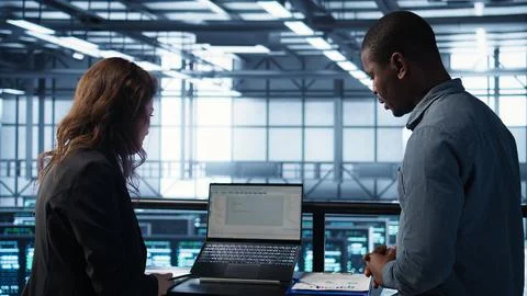 Server room coworkers using artificial intelligence on laptop and tablet Stock Photos
