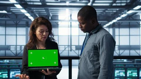 Server room coworkers using mockup notebook, adjusting power settings Stock Photos