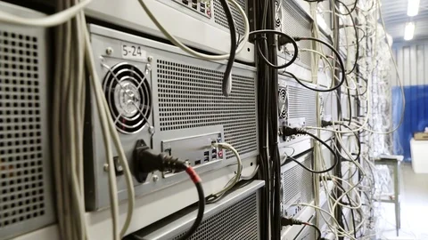 Server room for crypto currency mining farms with miners set up on wired shelves Stock Footage 106219256