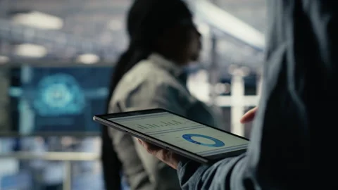 Server room employee checks data charts on tablet in server room 動画素材 314685849