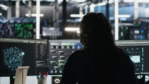 Server room expert interpreting AI data analytics graphs, putting on headphones Stock Photos
