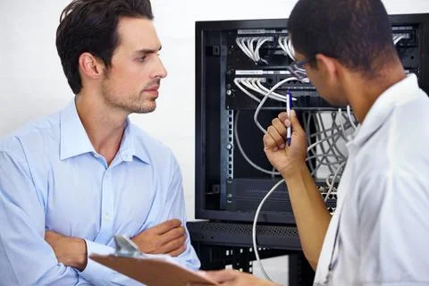 Server room, it support and cable with an engineer chatting to a business man Stock Photos