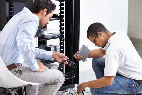Server room, man or technician fixing electronics for hardware maintenance or Stock Photos