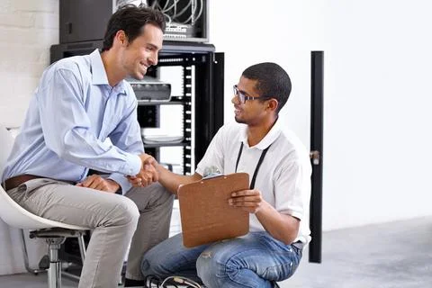 Server room, man or technician shaking hands for hardware maintenance success or Stock Photos
